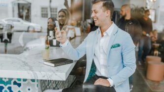 smiling man while holding smartphone