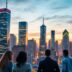 City skyline with tech buildings and professionals discussing growth.