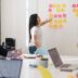 woman placing sticky notes on wall