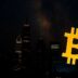 Golden Bitcoin symbol over a city skyline at night.