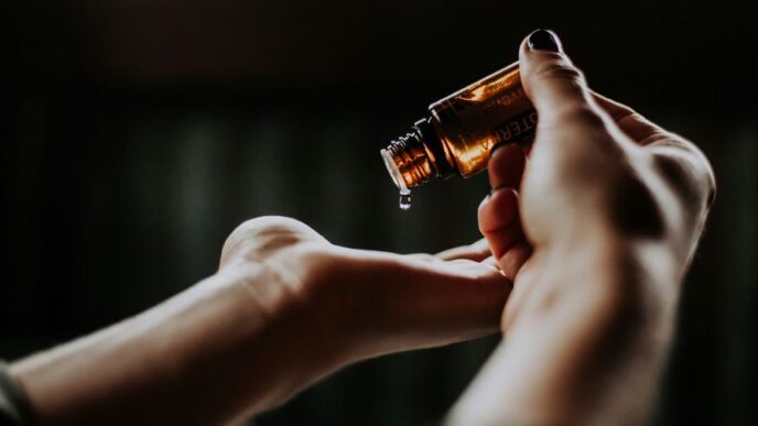 person holding amber glass bottle