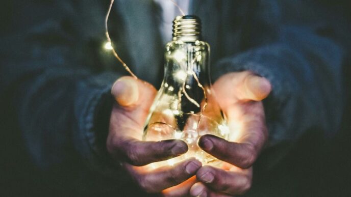 man holding incandescent bulb