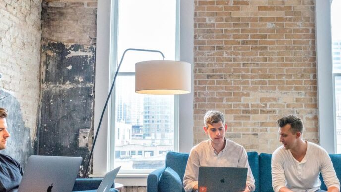 three men using MacBooks