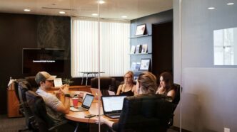 people sitting near table with laptop computer