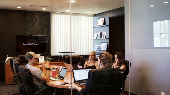 people sitting near table with laptop computer