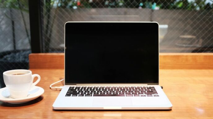 laptop computer beside coffee mug