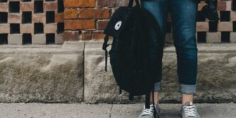 person standing near brown concrete wall