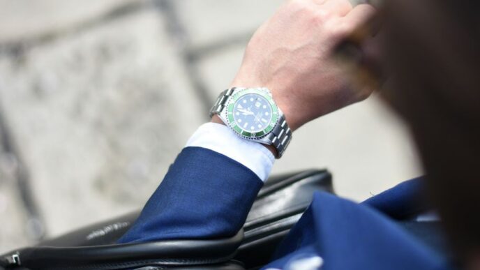 person looking at silver-colored analog watch