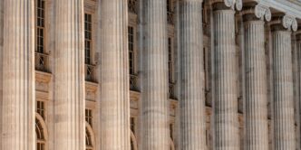 a large building with columns and a clock on the front of it