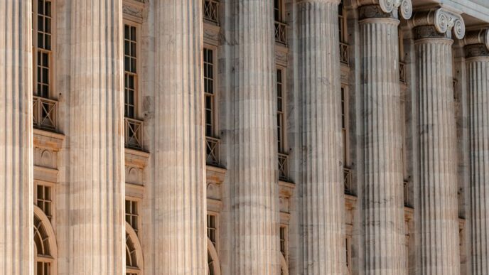 a large building with columns and a clock on the front of it