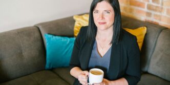 woman holding cup of coffee sitting on sofa
