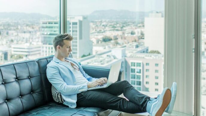 man sitting on sofa while using laptop