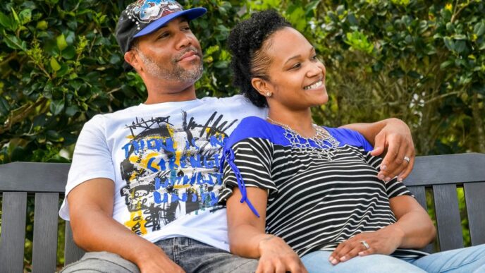man in white crew neck t-shirt sitting beside woman in black and white stripe shirt