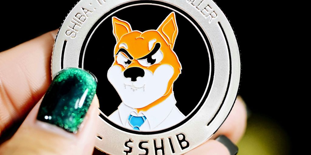 person holding white and black cat with green stone on hand