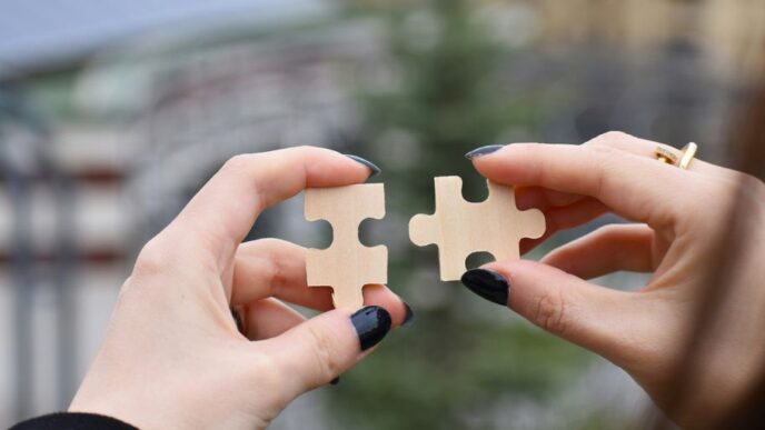 a few hands holding a small white object
