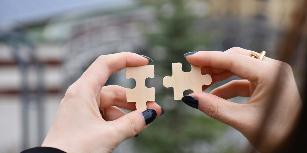 a few hands holding a small white object