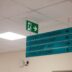 Hospital directional signs hang from the ceiling.