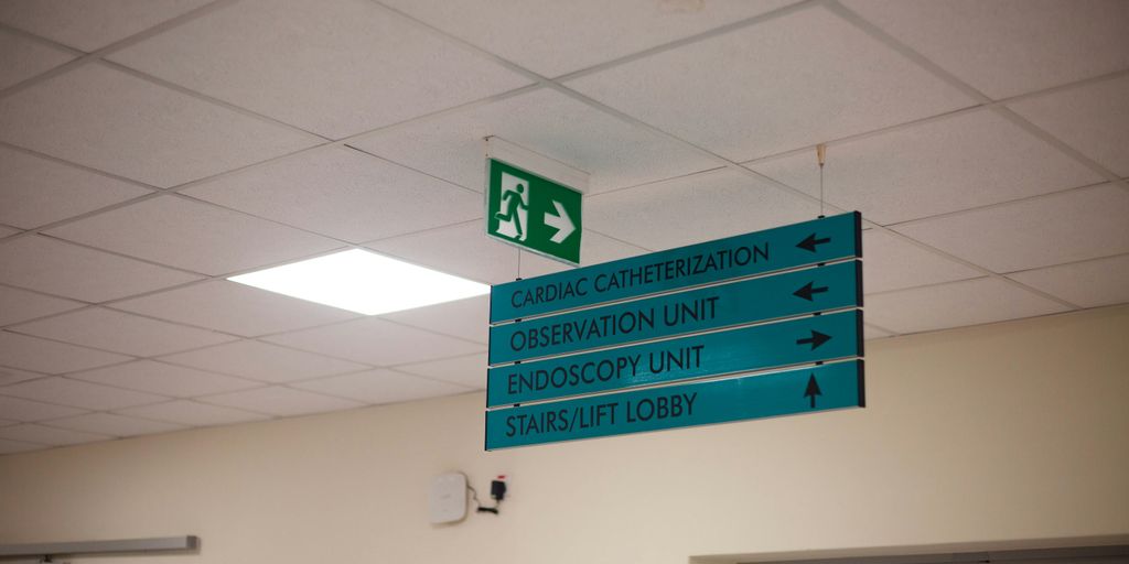 Hospital directional signs hang from the ceiling.