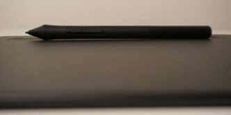 a black pen sitting on top of a laptop computer