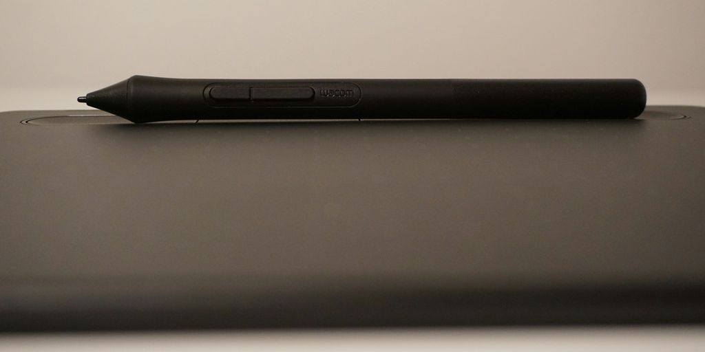 a black pen sitting on top of a laptop computer