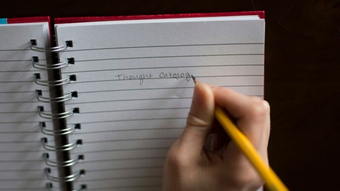 person writing on notebook
