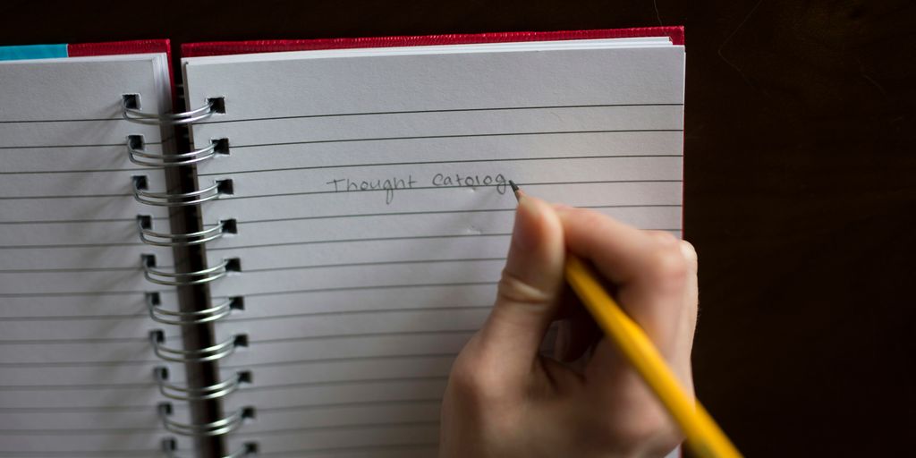 person writing on notebook