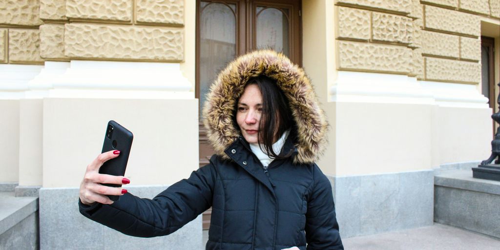 a woman in a parka holding a cell phone