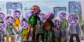 a couple of figurines that are standing in front of a wall