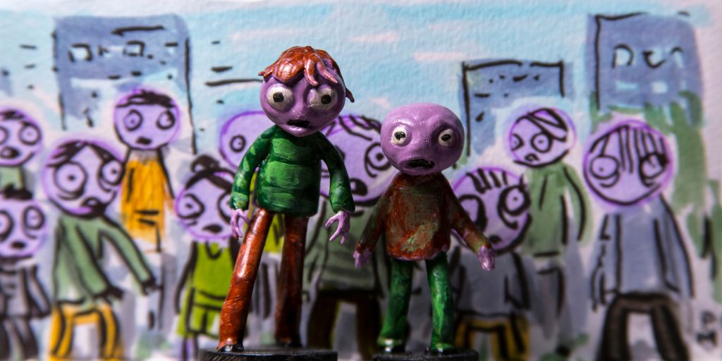 a couple of figurines that are standing in front of a wall