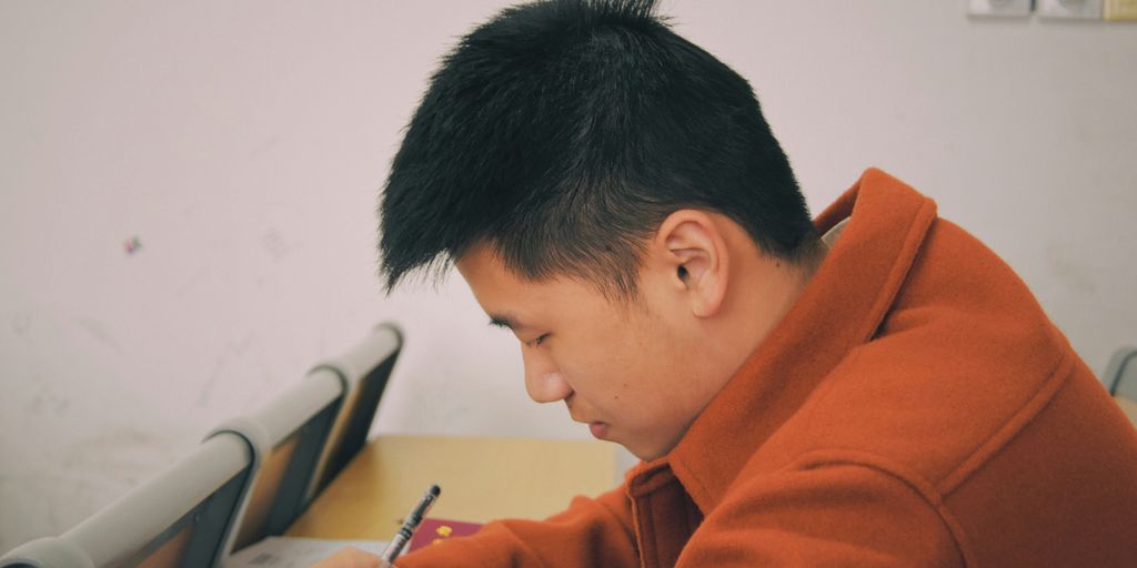 man in orange hoodie using smartphone