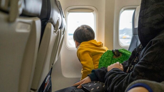 a small child sitting on a seat in an airplane