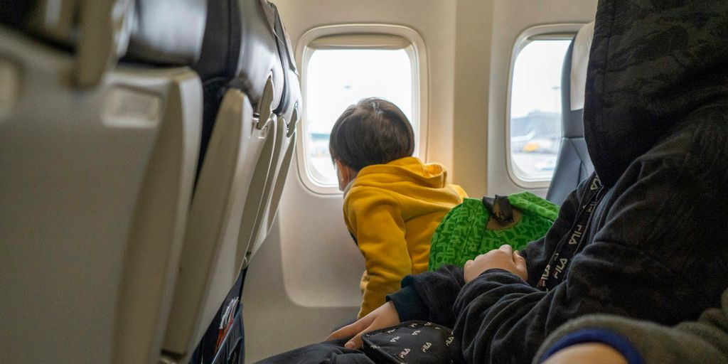 a small child sitting on a seat in an airplane