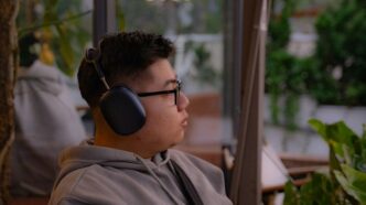 A young man listens to music outdoors.