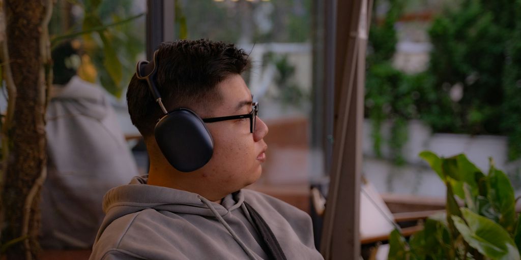 A young man listens to music outdoors.