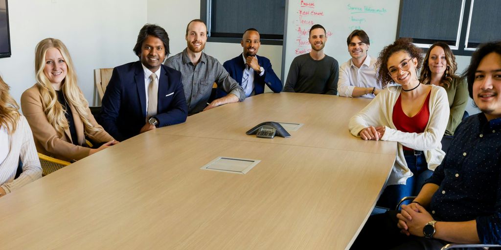 group of people sitting on chair in front of brown wooden table