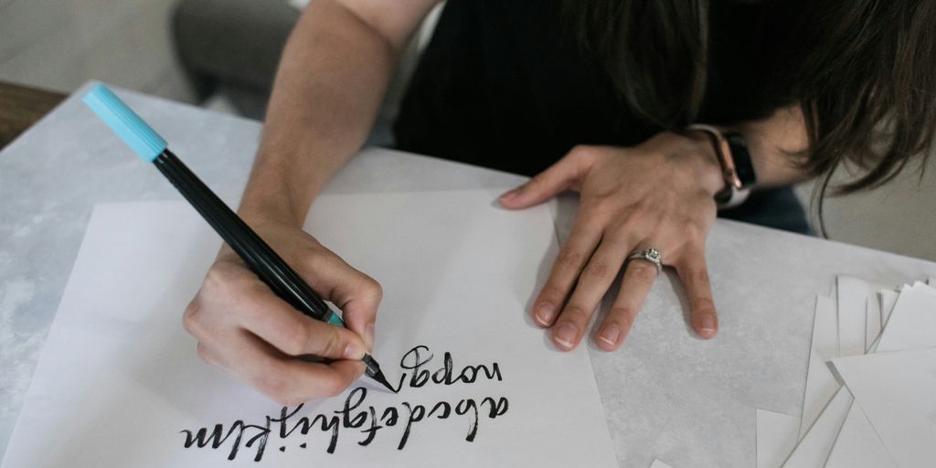 woman in black shirt writing on white paper