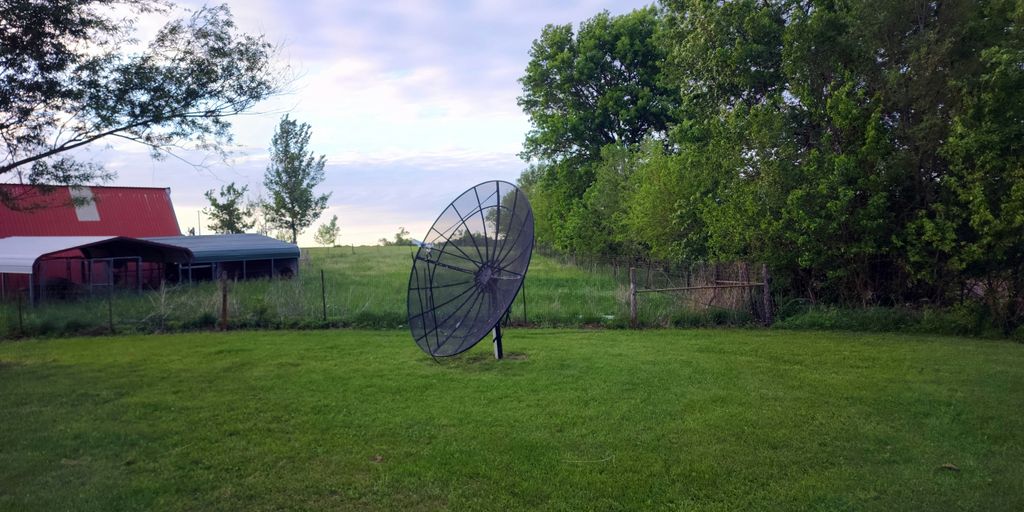 a large metal object sitting on top of a lush green field