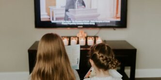 girl in white and black polka dot shirt watching tv