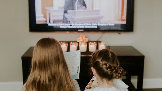 girl in white and black polka dot shirt watching tv
