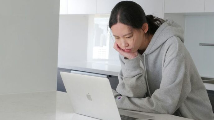 man in gray hoodie sitting beside white table