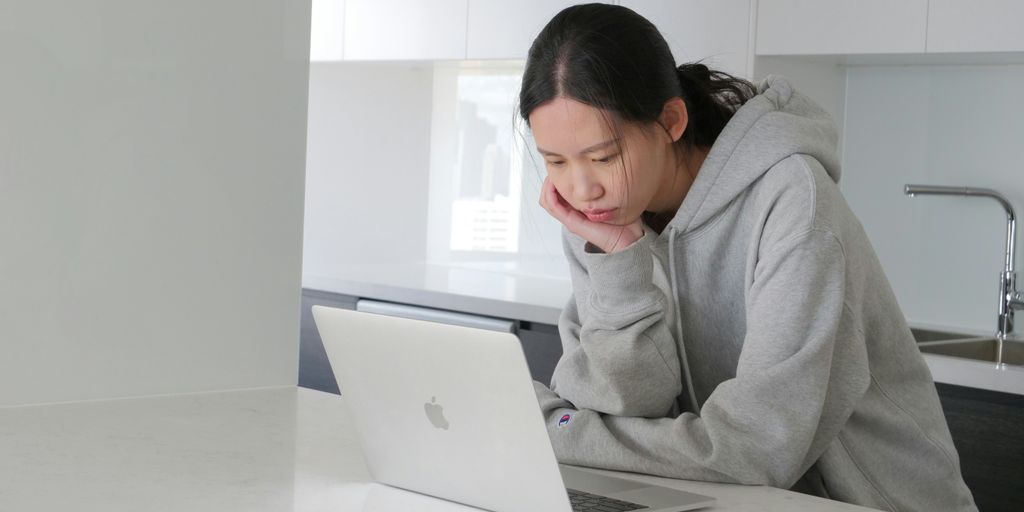 man in gray hoodie sitting beside white table