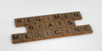 scrabble tiles spelling the word regimen beats medicine