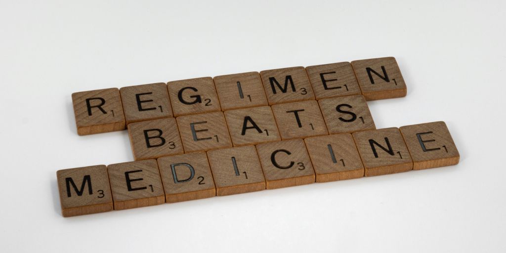 scrabble tiles spelling the word regimen beats medicine