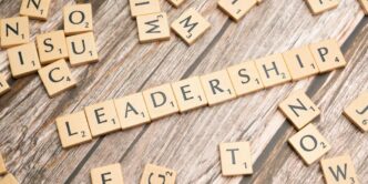 scrabble tiles spelling out the word leadership on a wooden surface