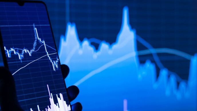 a person holding a cell phone in front of a stock chart