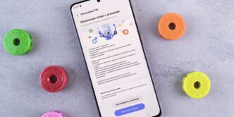 A cell phone sitting on top of a table next to doughnuts