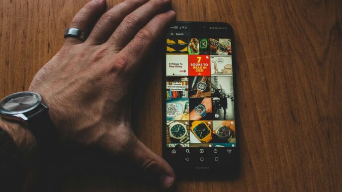 a person holding a smart phone on top of a wooden table