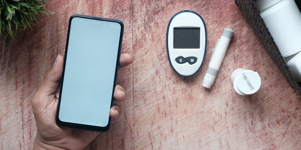 a person holding a smart phone next to an electronic device