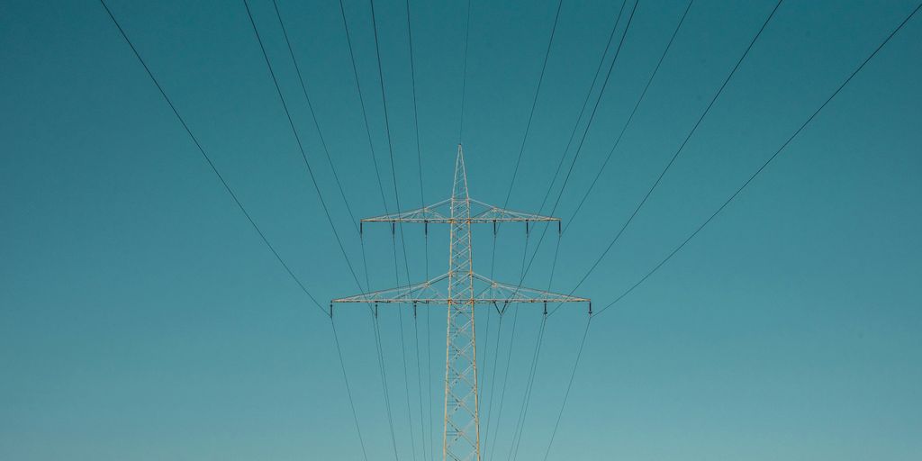 white electric post under blue sky during daytime