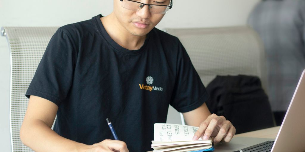 man writing on paper
